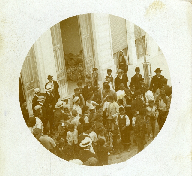 Sepia toned photograph of a crowd of people in the street