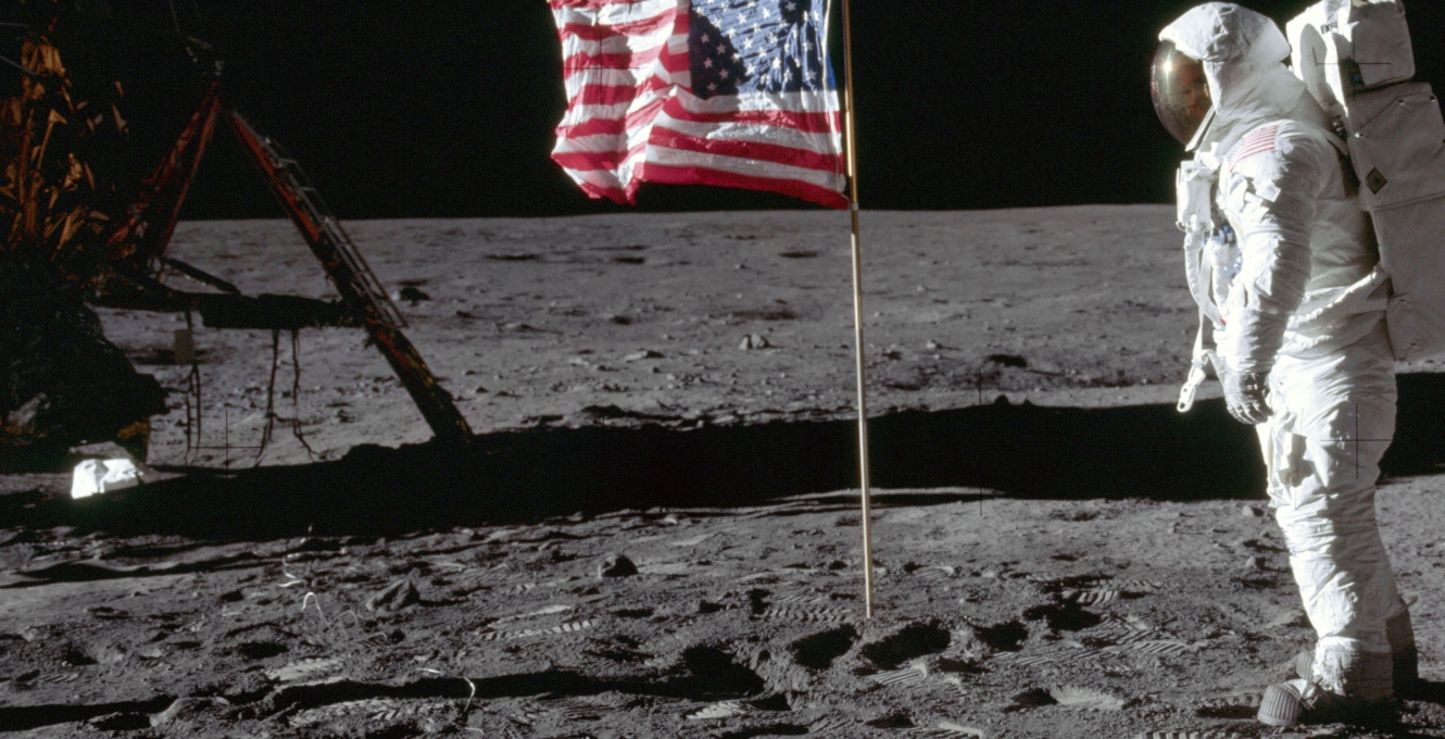 Astronaut Buzz Aldrin standing before the American flag during the moon landing 