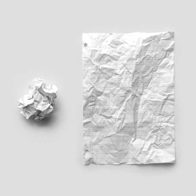 a crumpled paper next to a paper that has been flattened, but still shows wrinkles