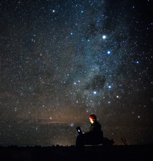 Person on computer under starry sky