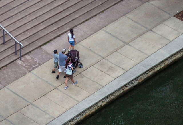 An aerial view of a family walking on a sidewalk