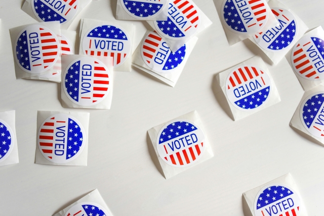 Scattered "I voted" stickers with american flag graphics