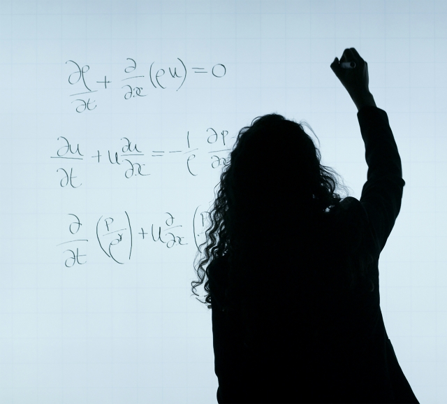 Woman aerospace engineer writes equations on whiteboard