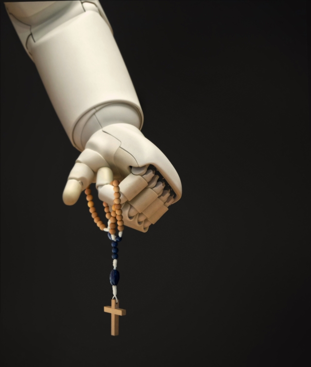 Robot hand holding rosary.