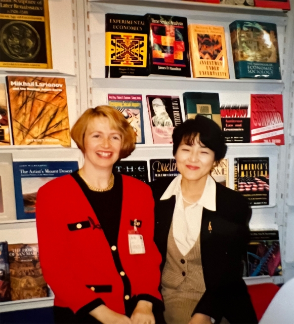 Two women in front of large book display.