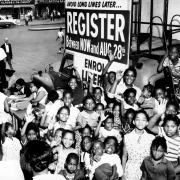 African American children in front of a voter registration table.