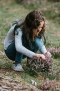 girl looking for bugs in a heather plant