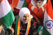 Old woman in a crowd holding an Indian flag