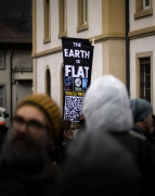 person in a crowd carrying an earth is flat poster