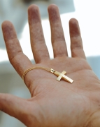 hand holding a cross necklace